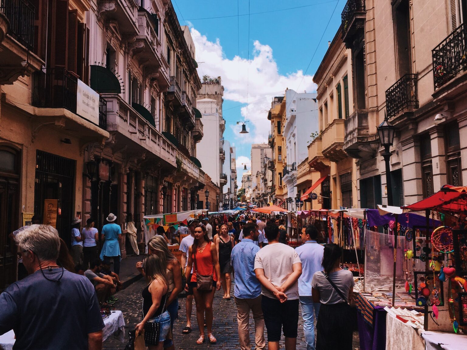 Crowded street market with historic Buenos Aires buildings.