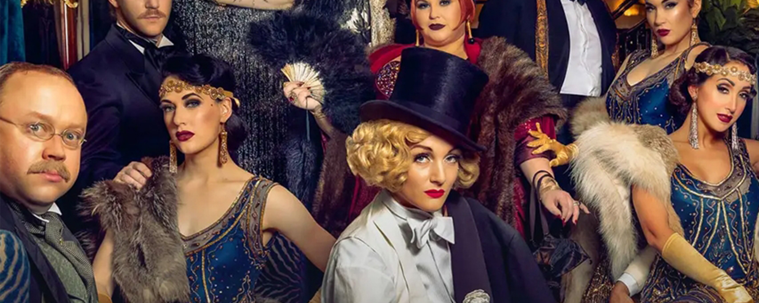 Group of people in 1920s style train car.