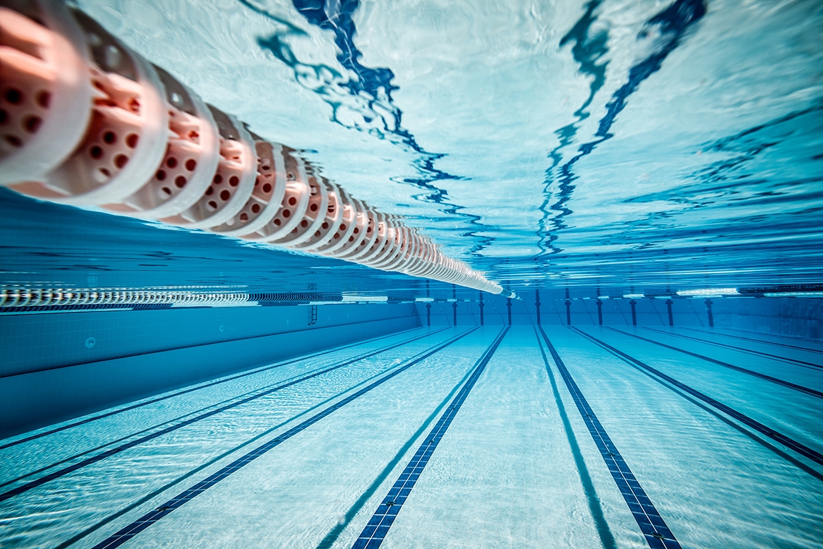 Underwater view of empty blue swimming pool.