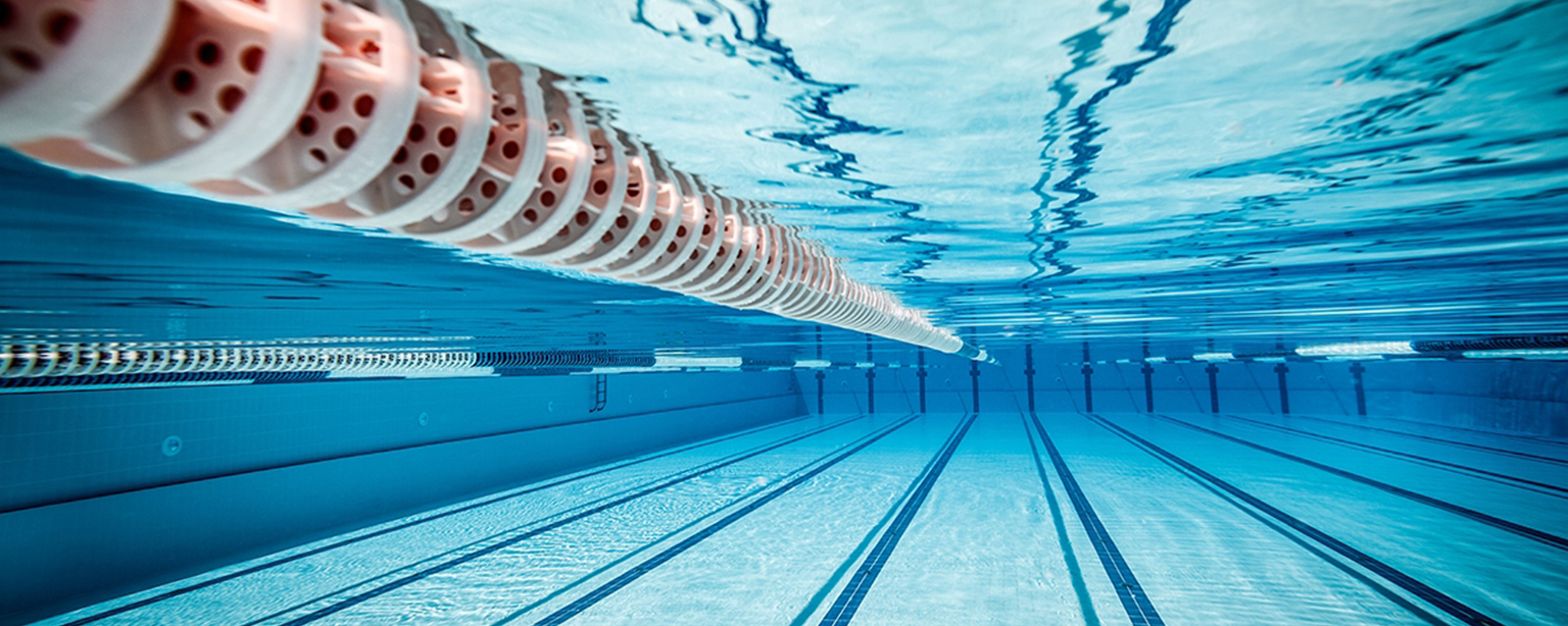 Underwater view of empty blue swimming pool.