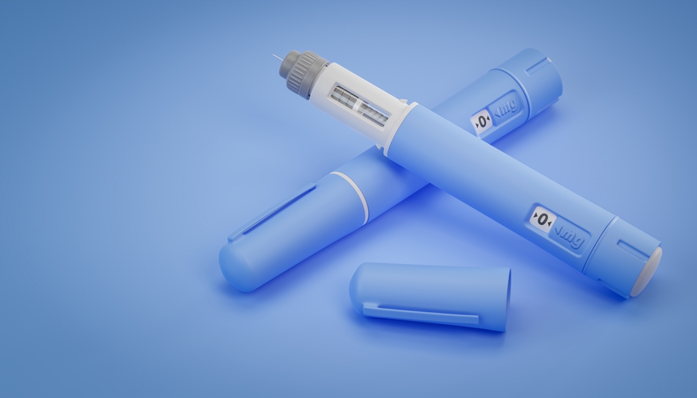 Two blue injectable medical pens on surface.