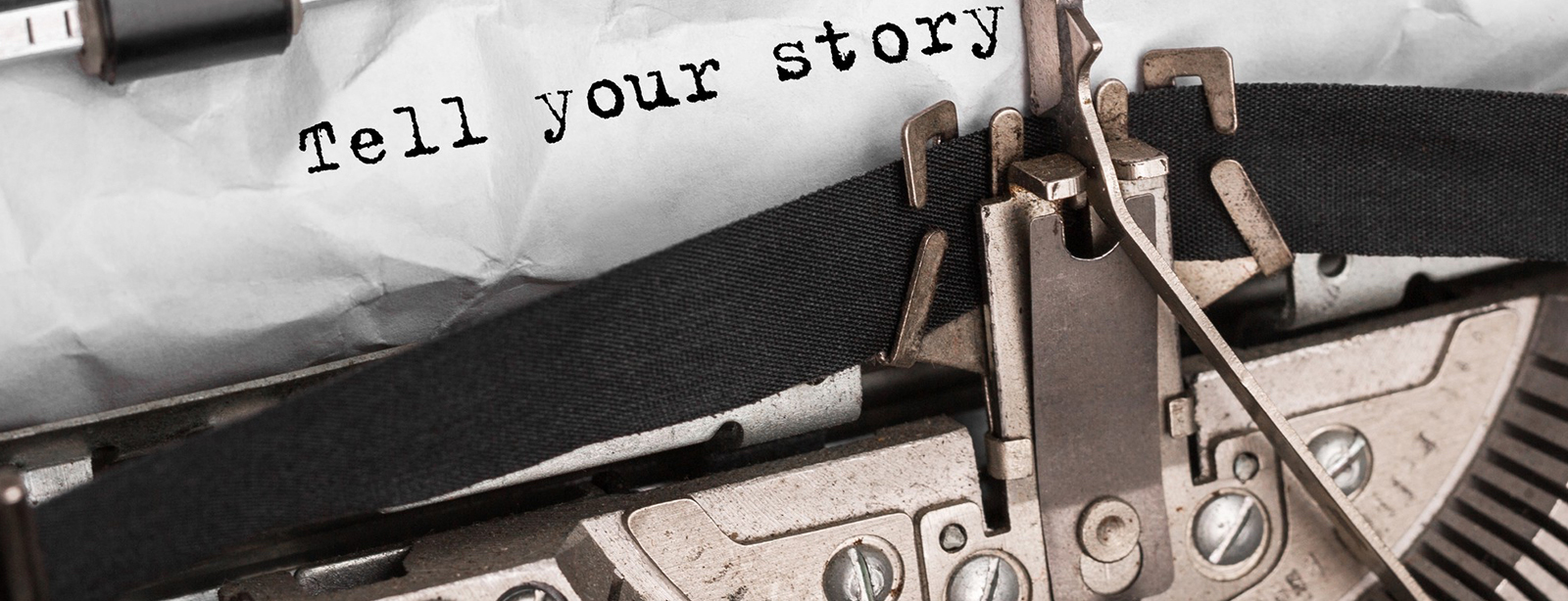 Antique typewriter with "Tell your story" on paper.