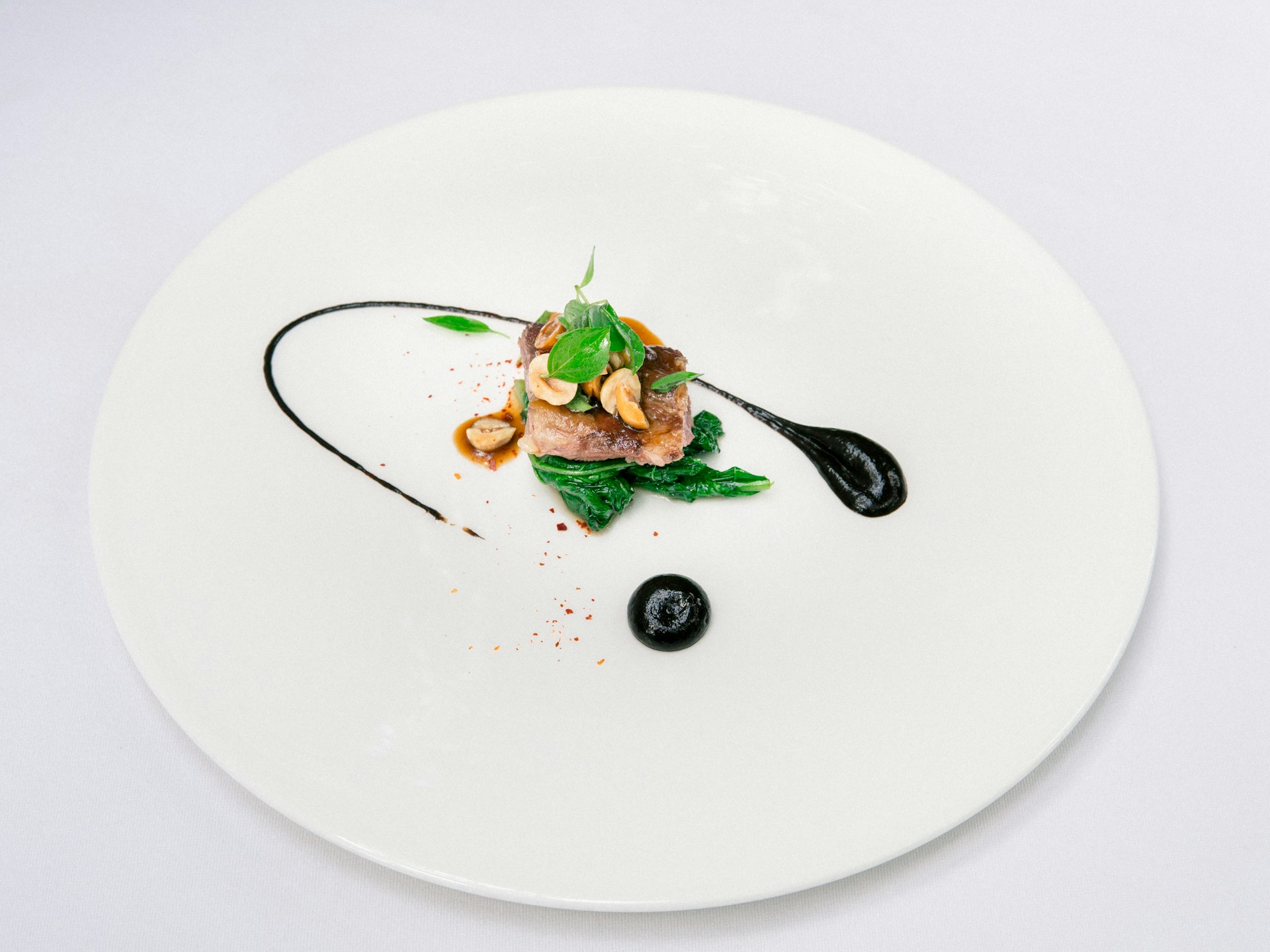 Elegant small meat dish with black sauce.