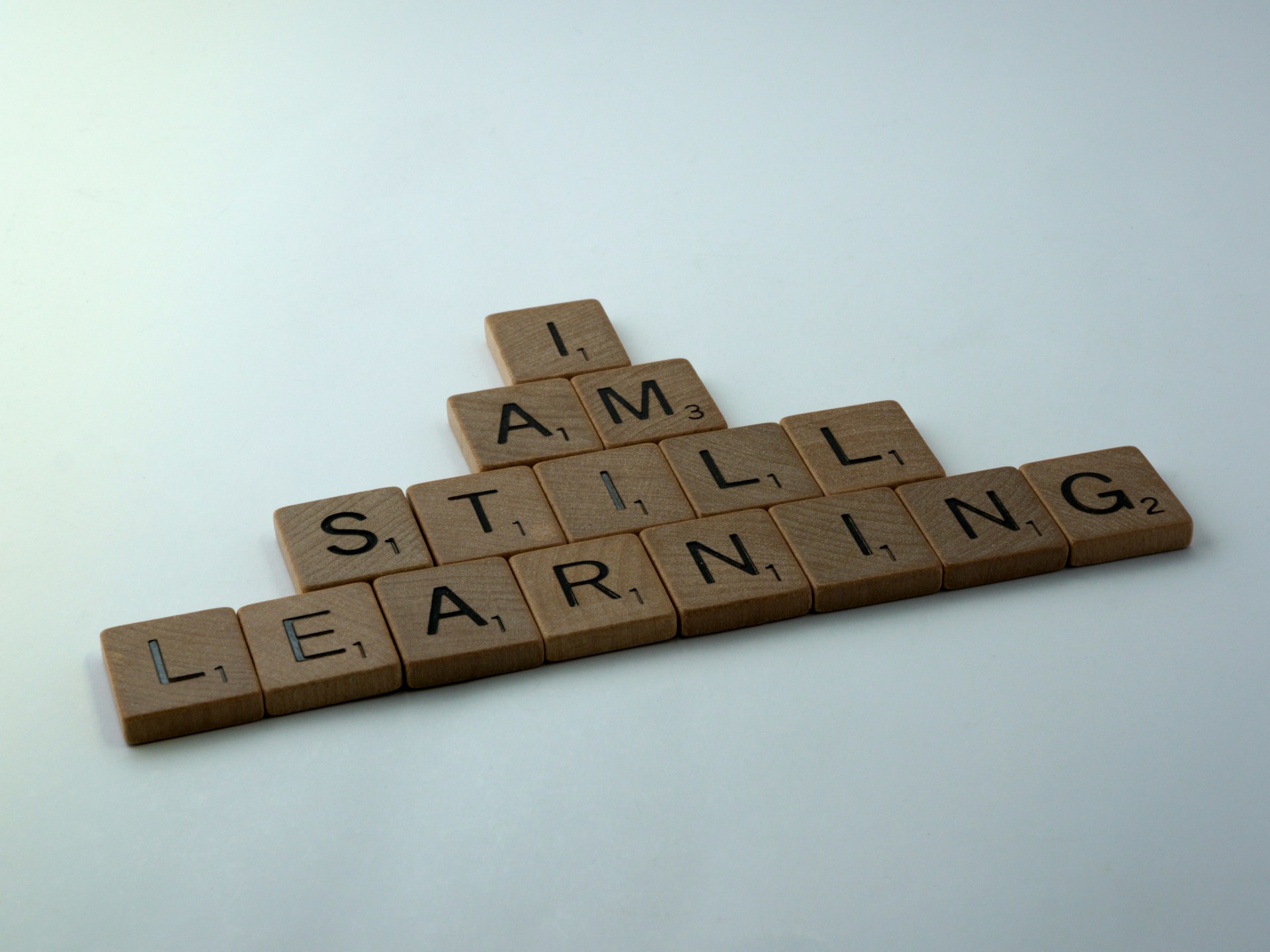 Scrabble tiles spell "I am still learning."
