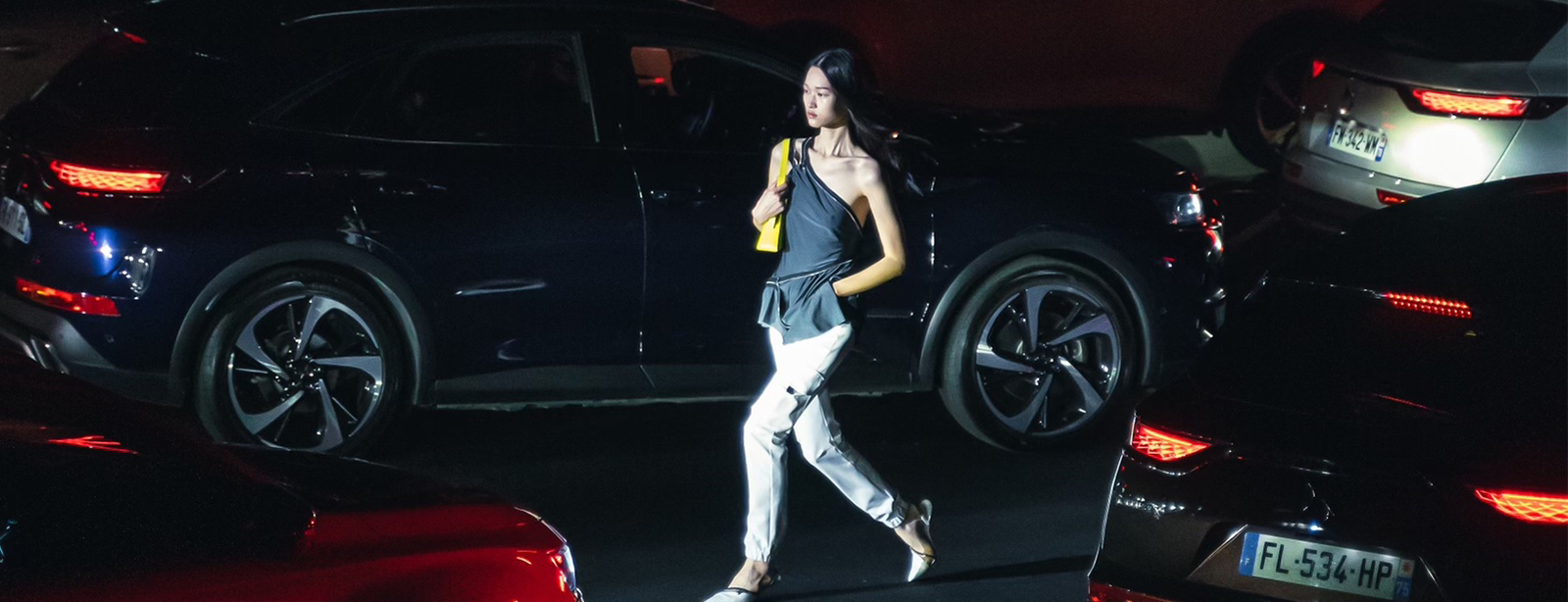 Fashion model walking through dark car park.