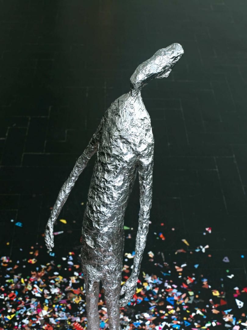 Foil figure on confetti floor.