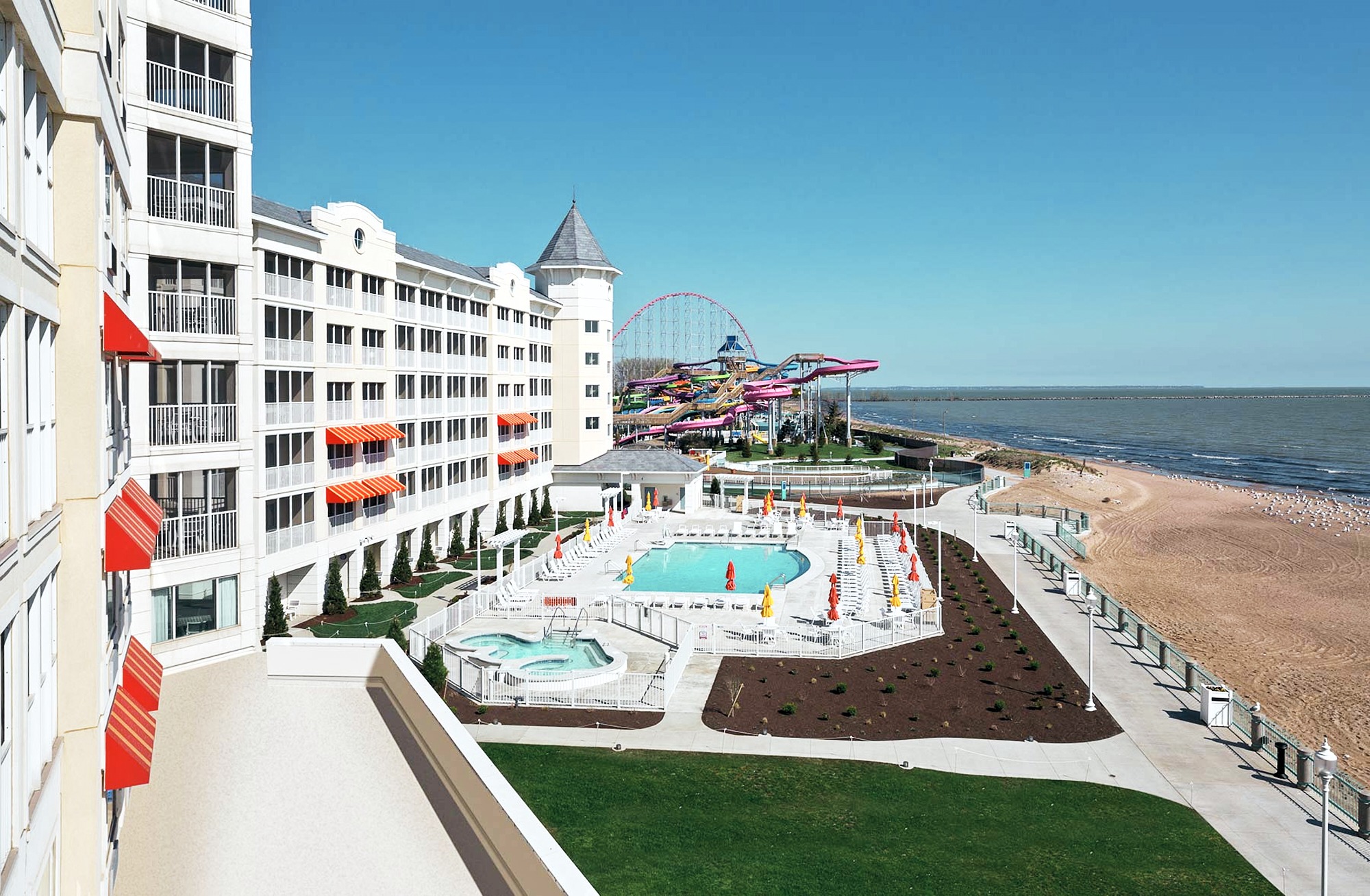 White hotel building overlooks sunny ocean beach