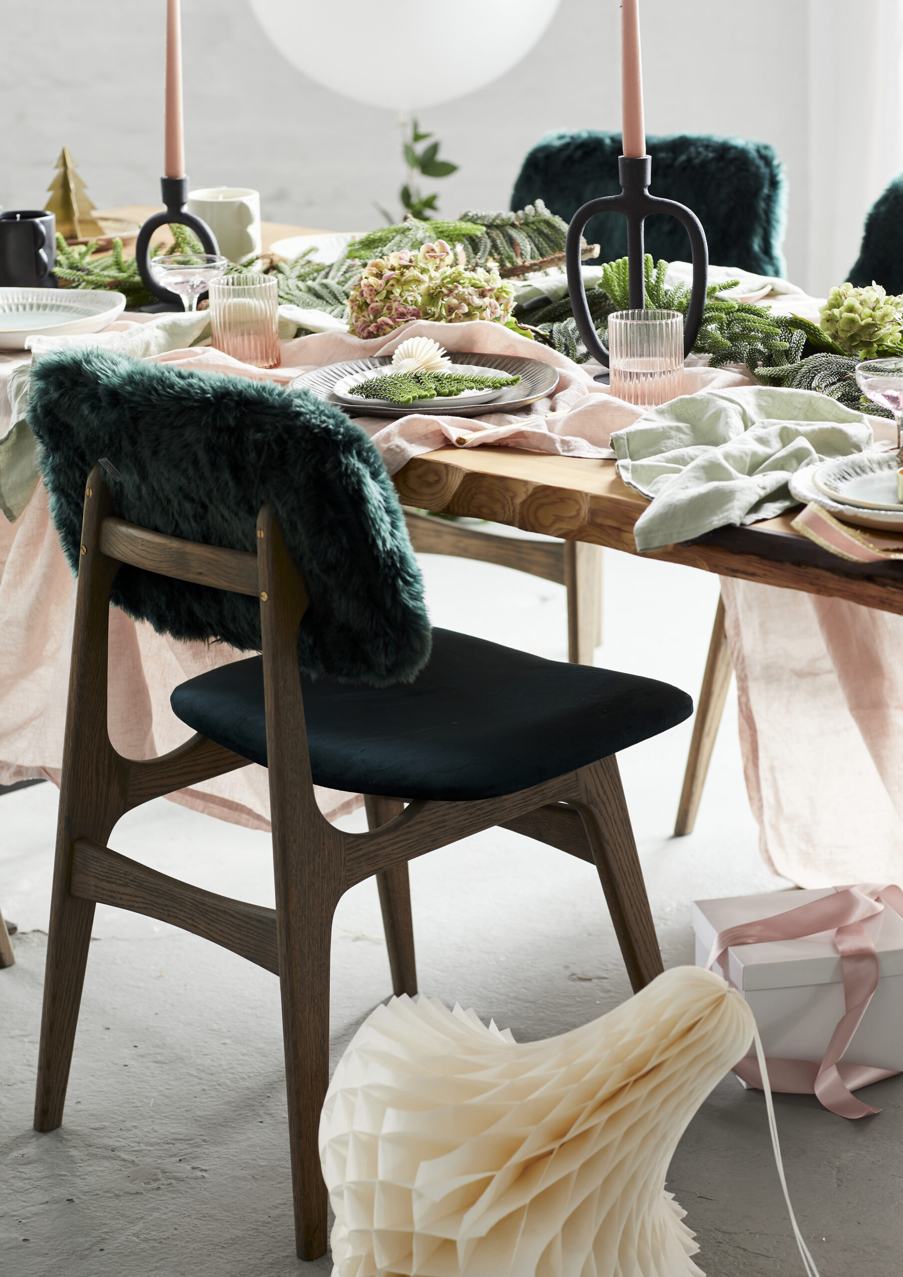Green faux fur chair detail at rustic wood dining table.