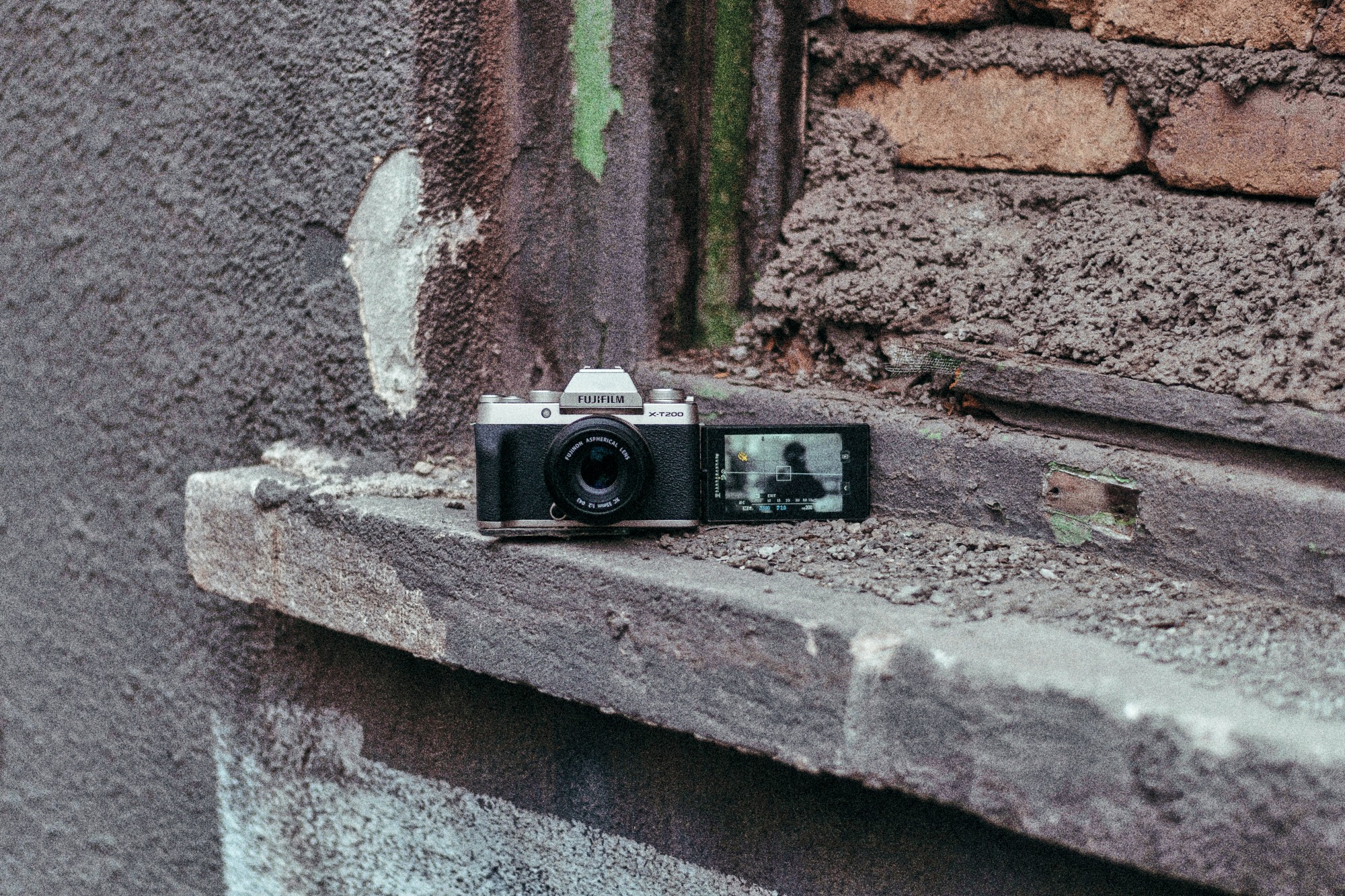 Two small cameras resting on a stone ledge