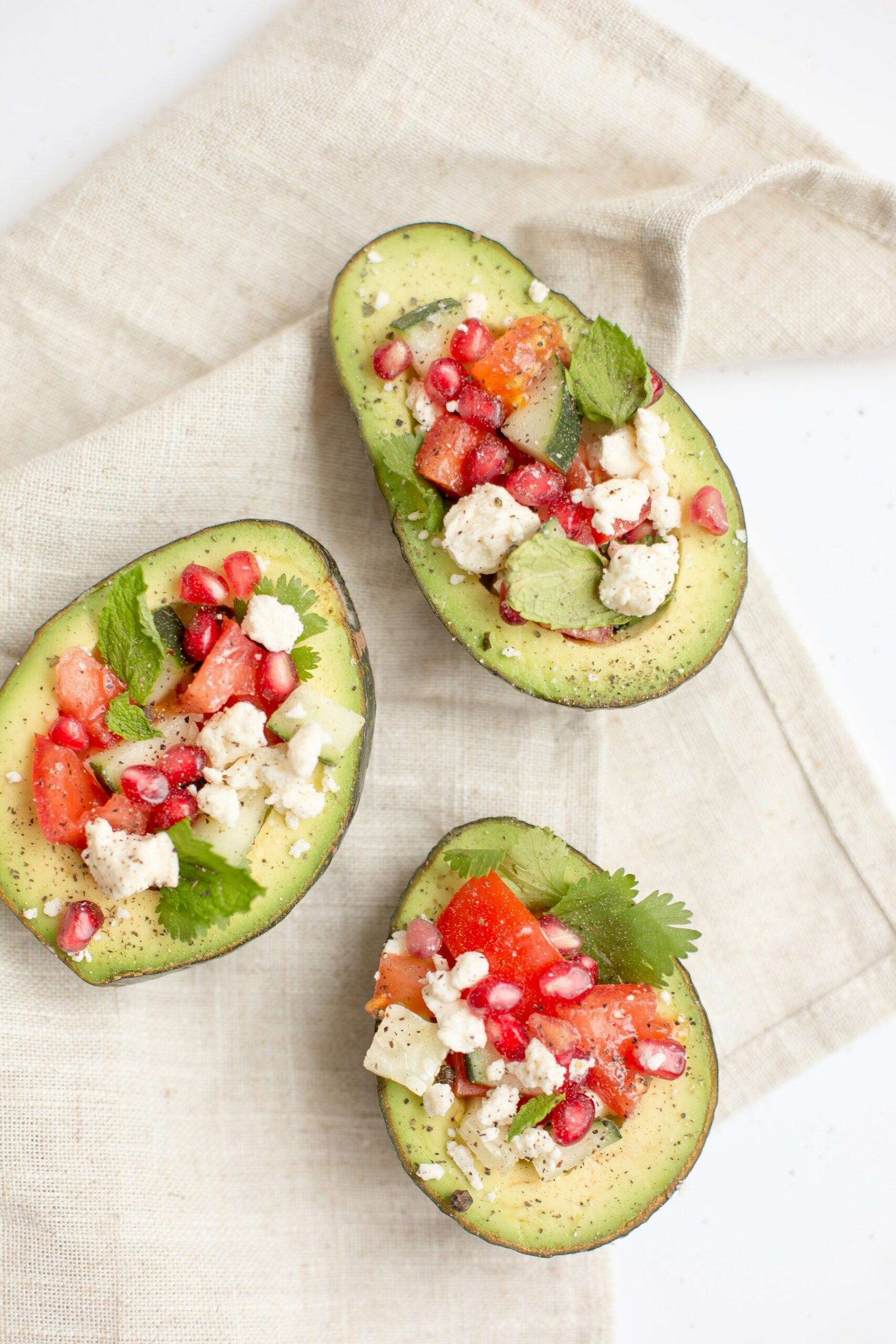 Avocados stuffed with pomegranate, cucumber, and feta cheese.