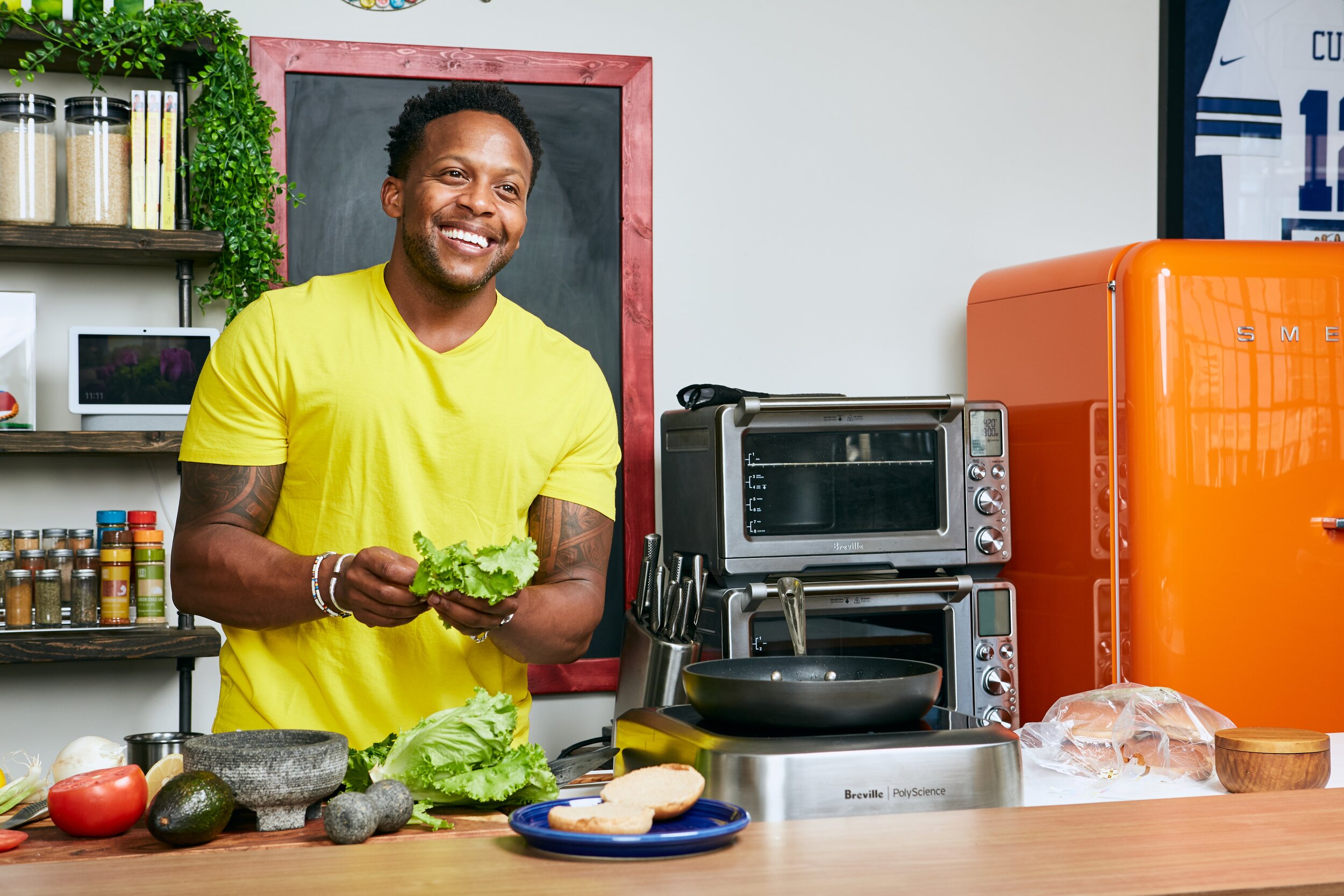 Kevin Curry smiles while holding fresh lettuce.
