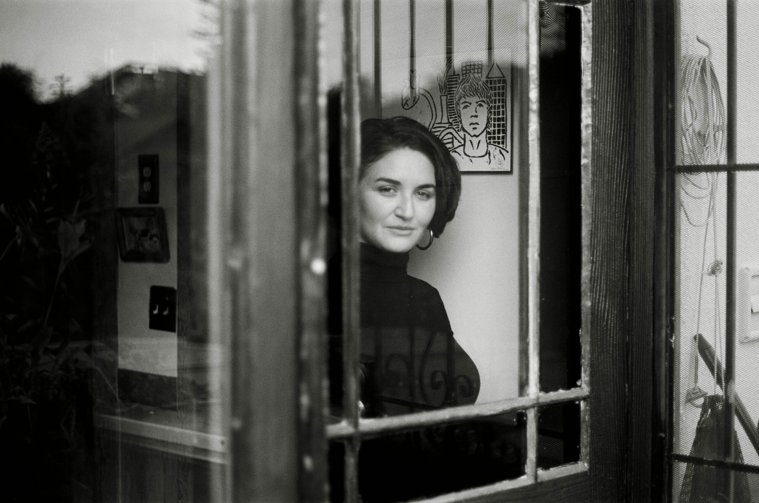 Black and white portrait through window pane.