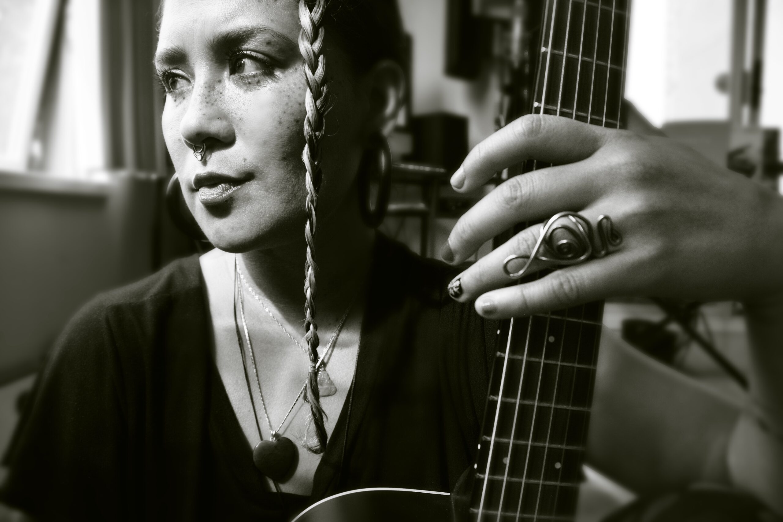 Musician with guitar, ring visible on hand.