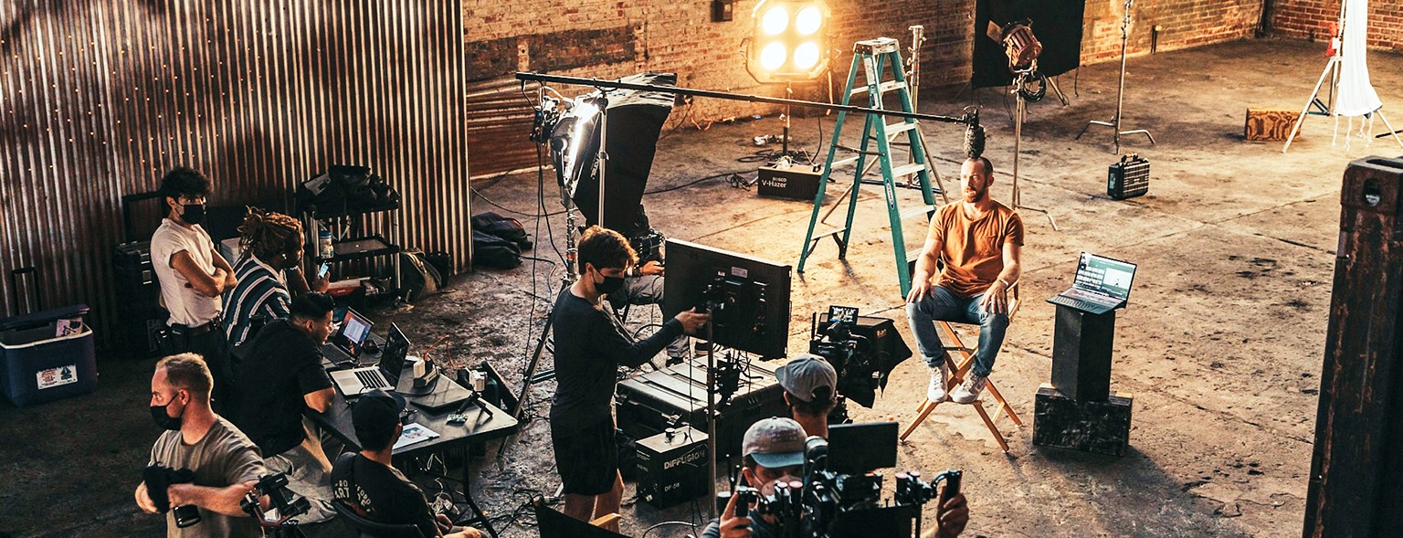 Film set lighting and equipment behind actors