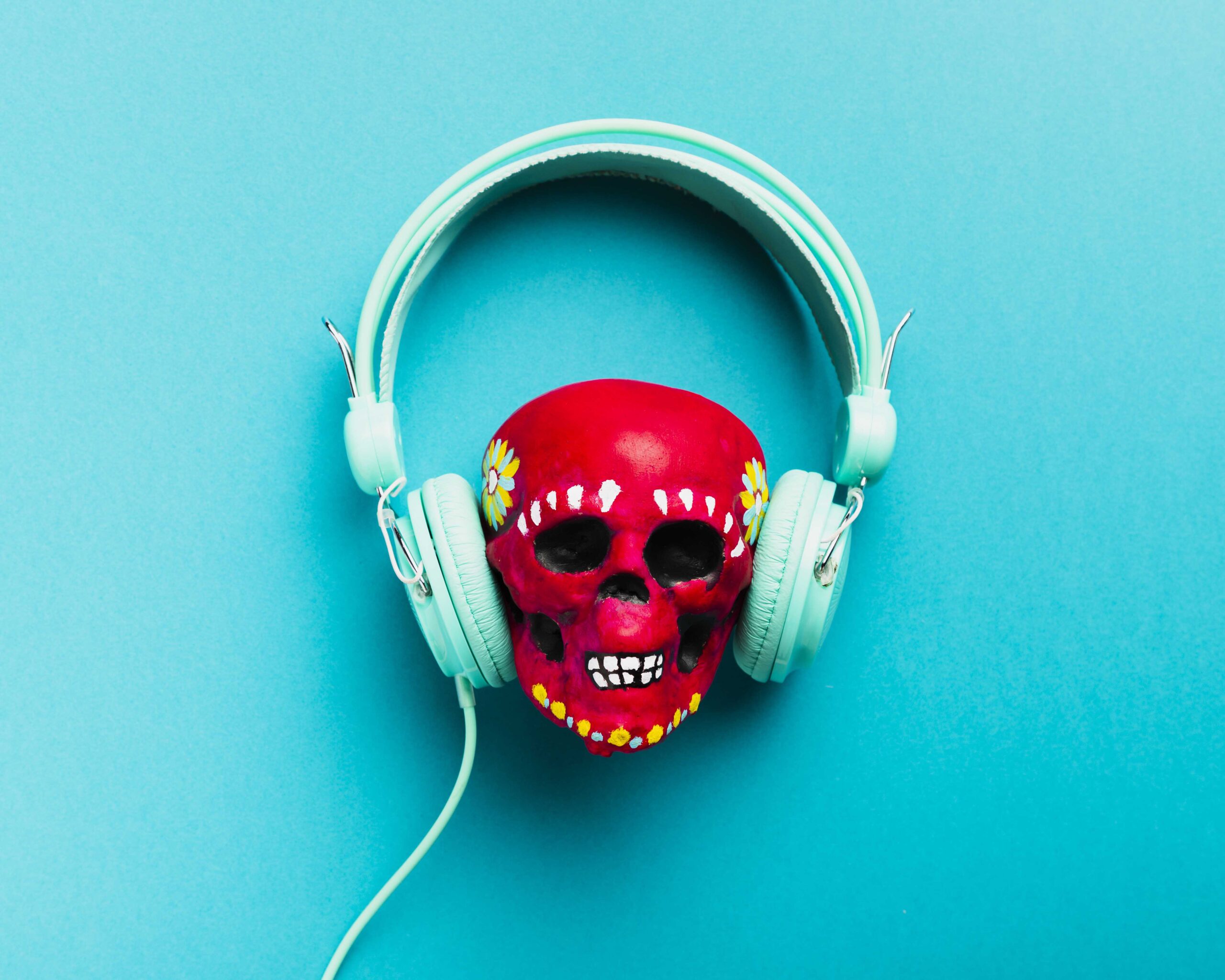 Red painted skull with light blue headphones.