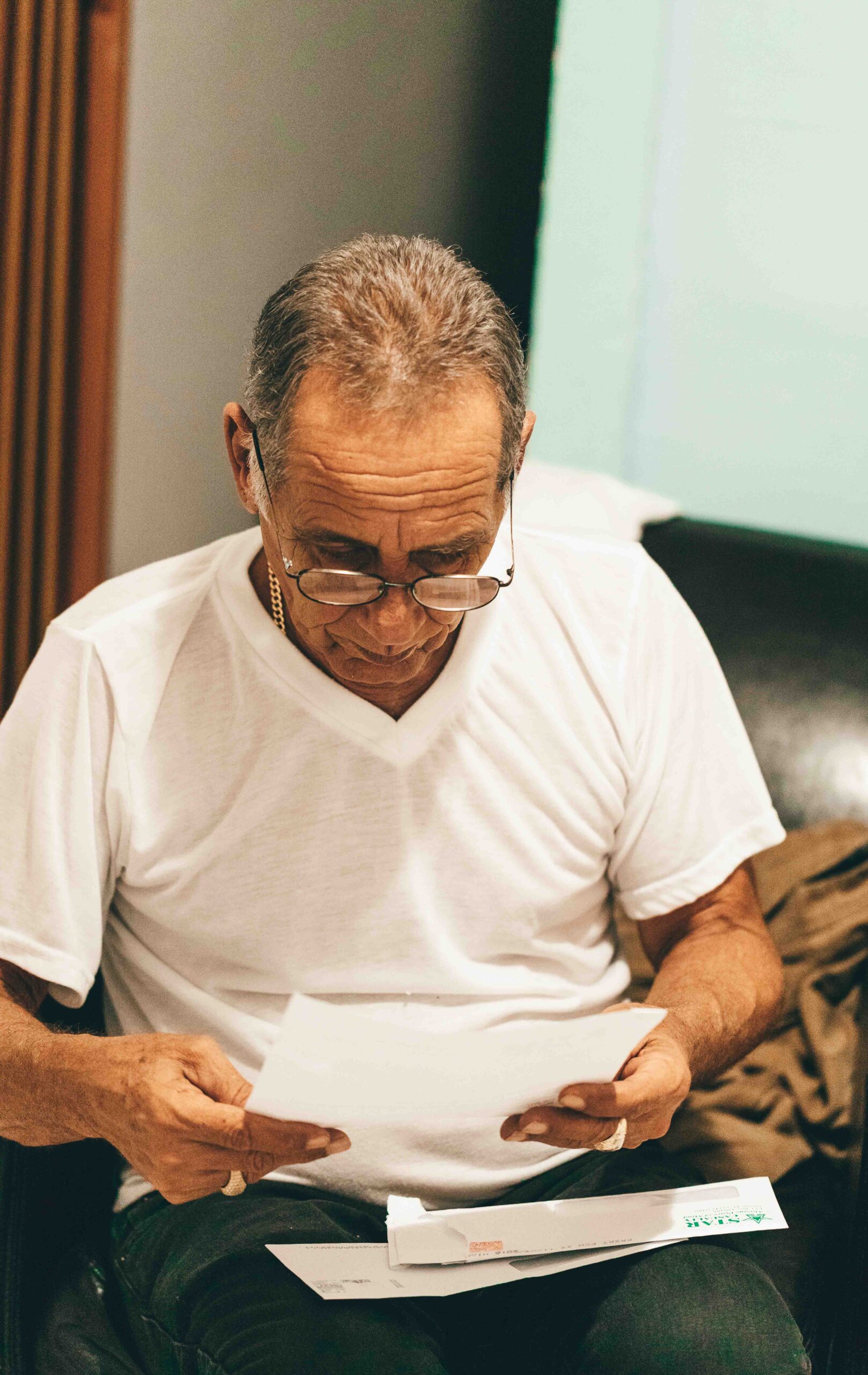 Older man intently reading a piece of paper.