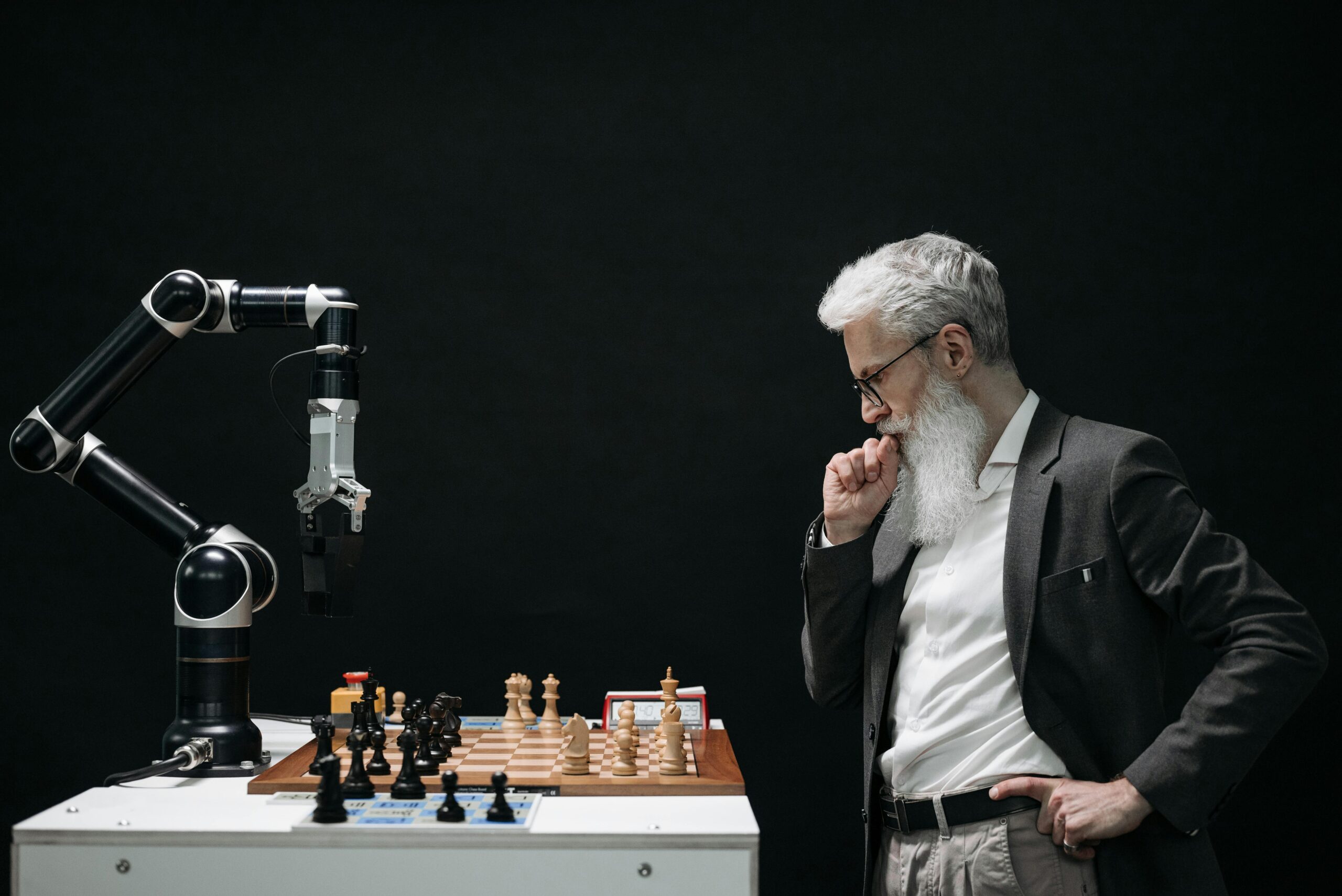 An older man with a robotic arm playing chess