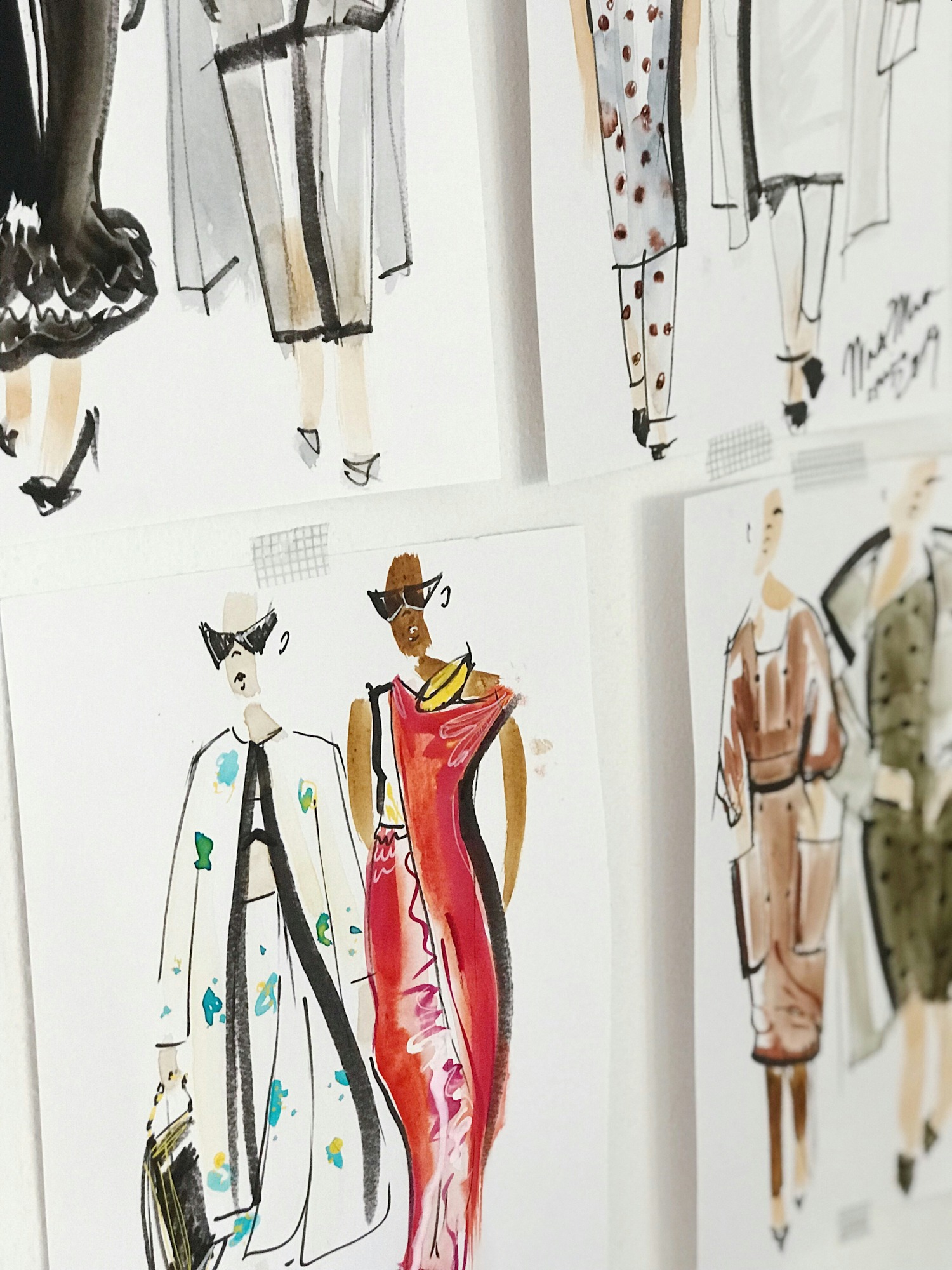 Fashion sketches and illustrations on a white wall