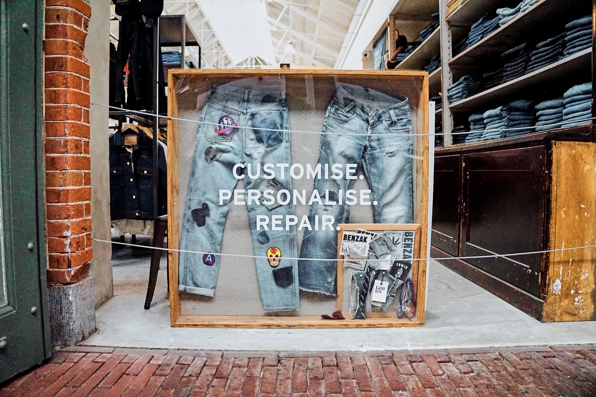 Old jeans displayed in a clear wooden box