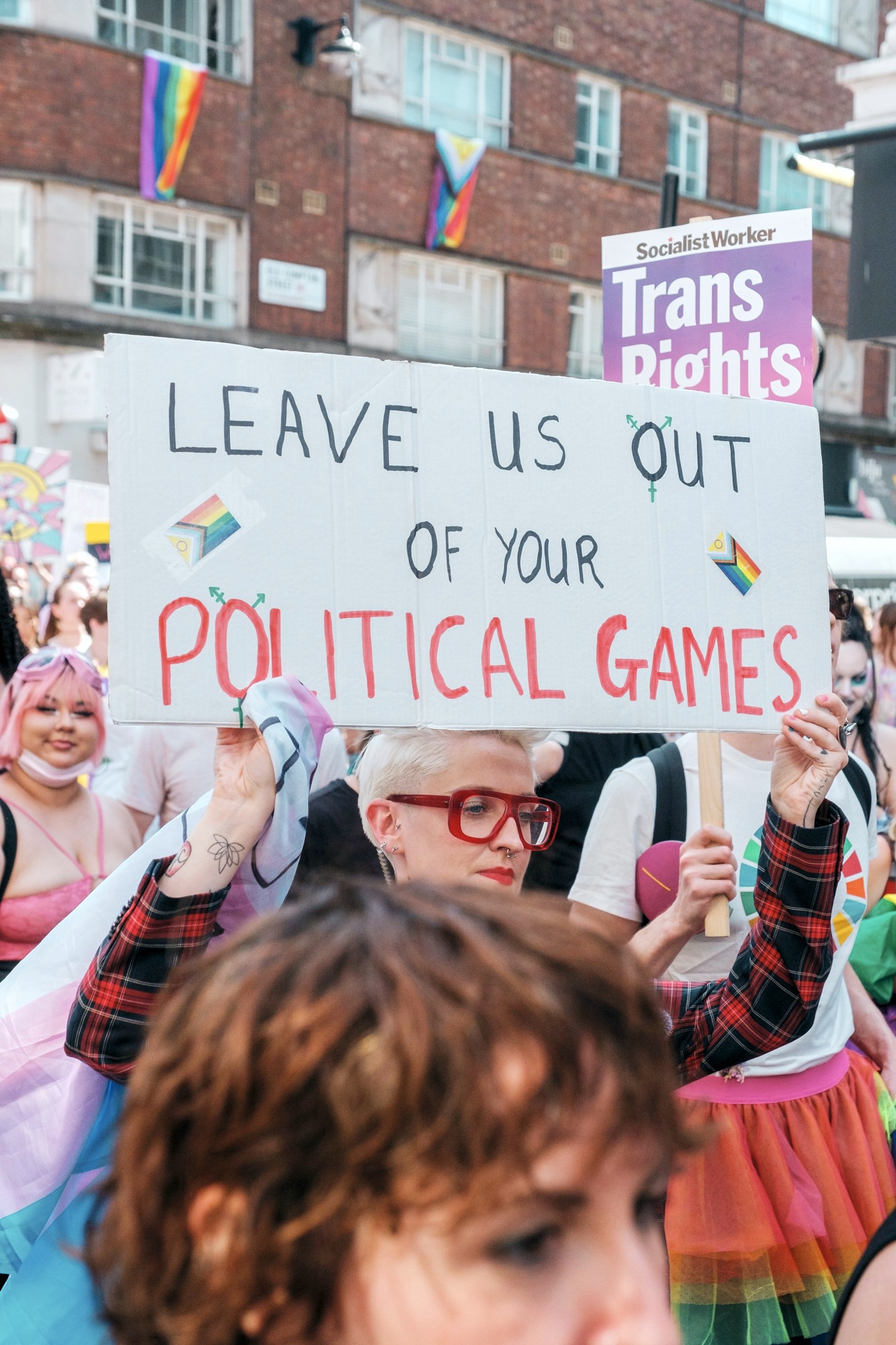 Protest sign says "Leave Us Out" at rally