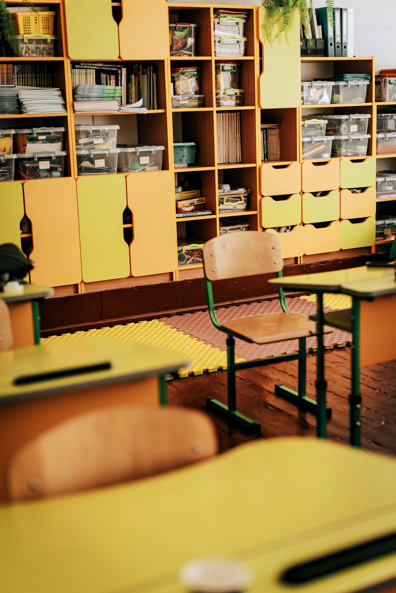 Empty yellow school desks in a classroom