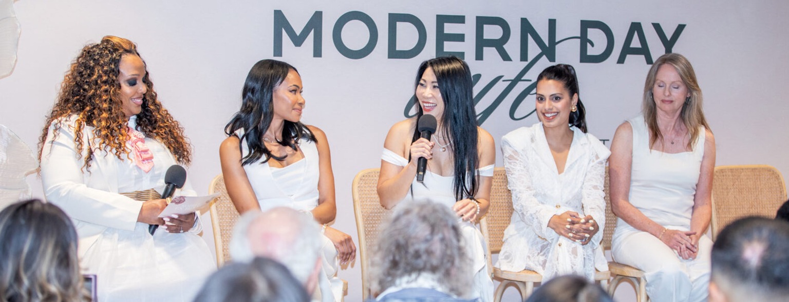 All-female panel discussing on stage with audience