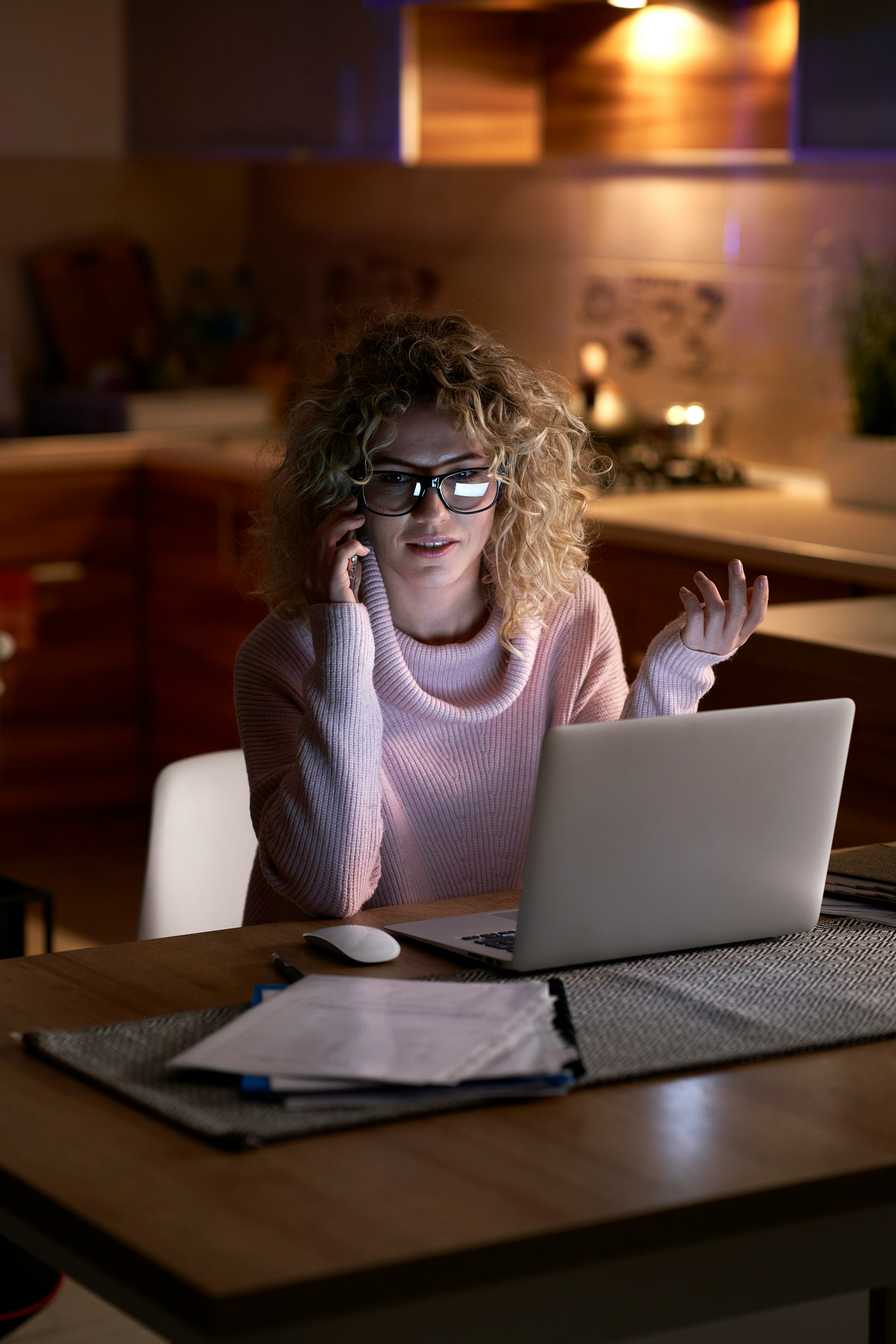 Woman with glasses working late on laptop