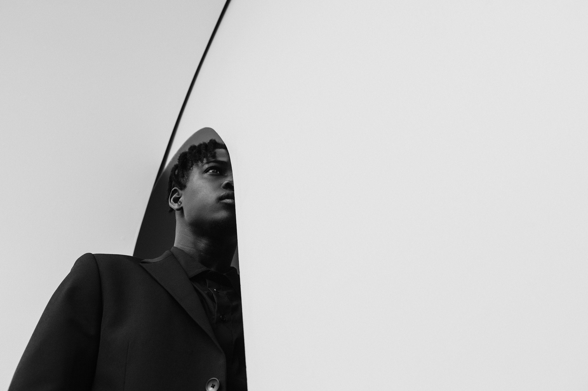 Man in black silhouette against white corner