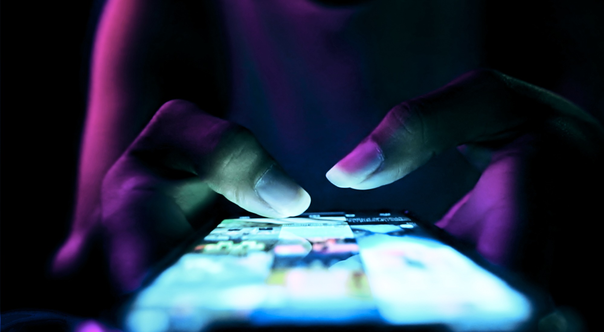 Close-up hands glowing light using a phone