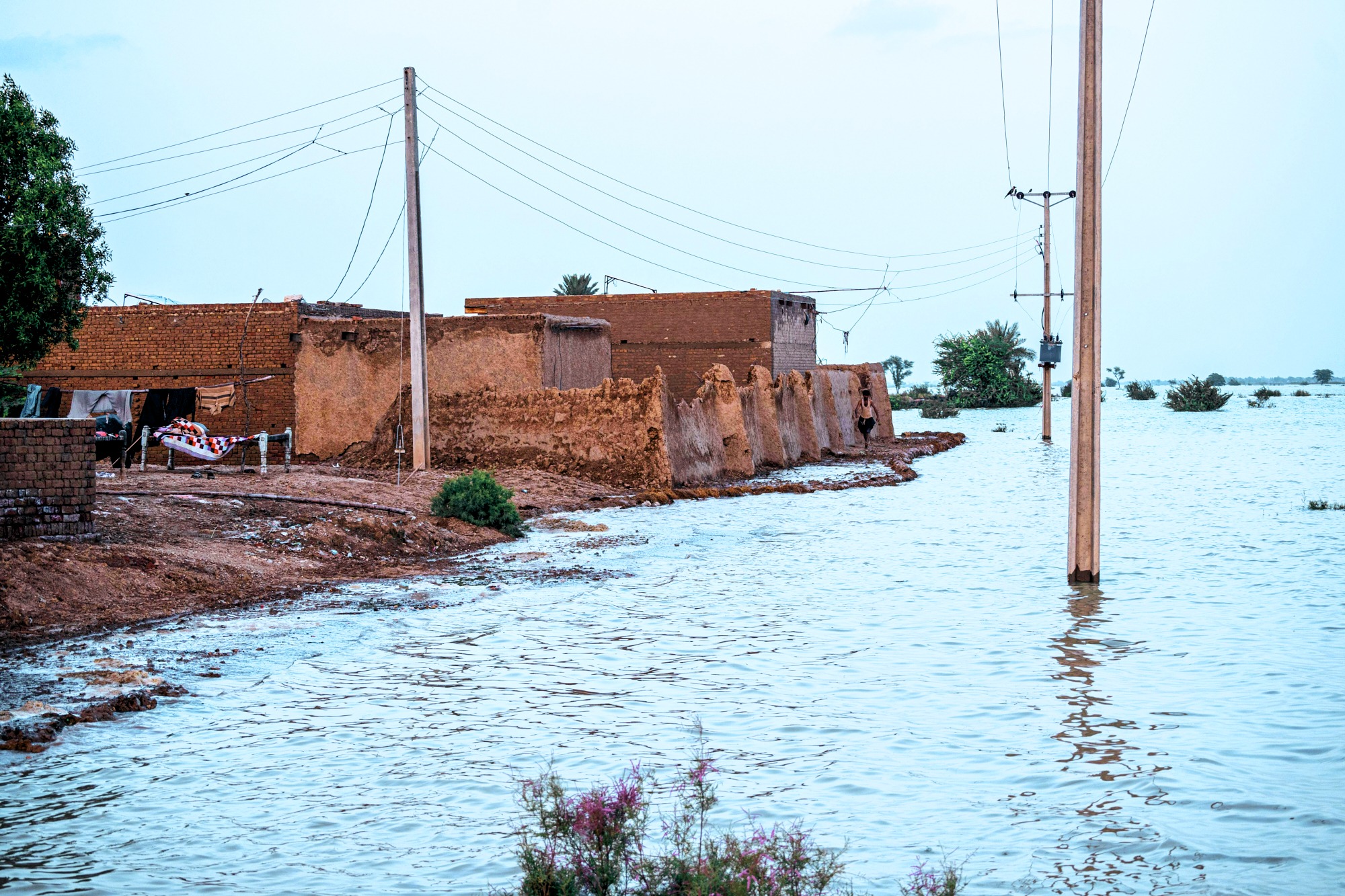 Mud brick homes partially surrounded by floodwater